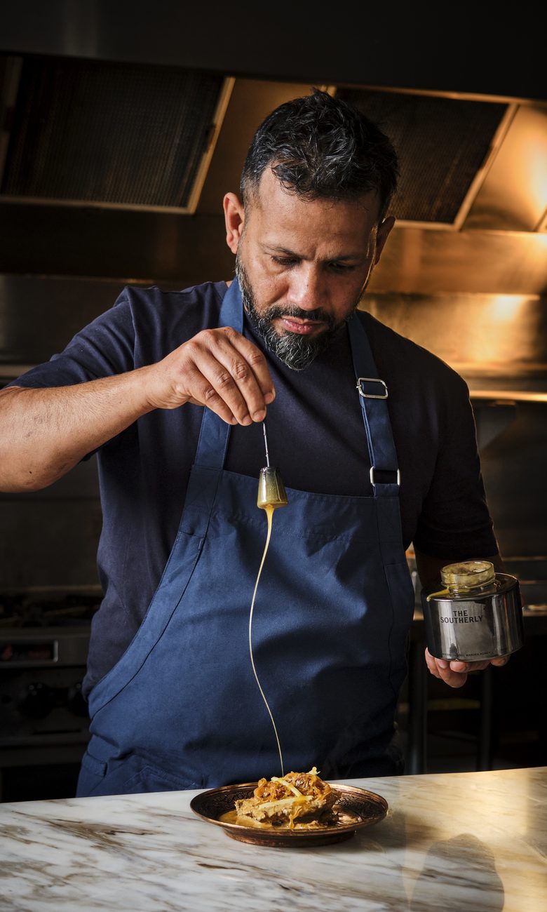 Chef Sid Chopra finishing a dish by hand at the pass at GOAT, Auckland CBD